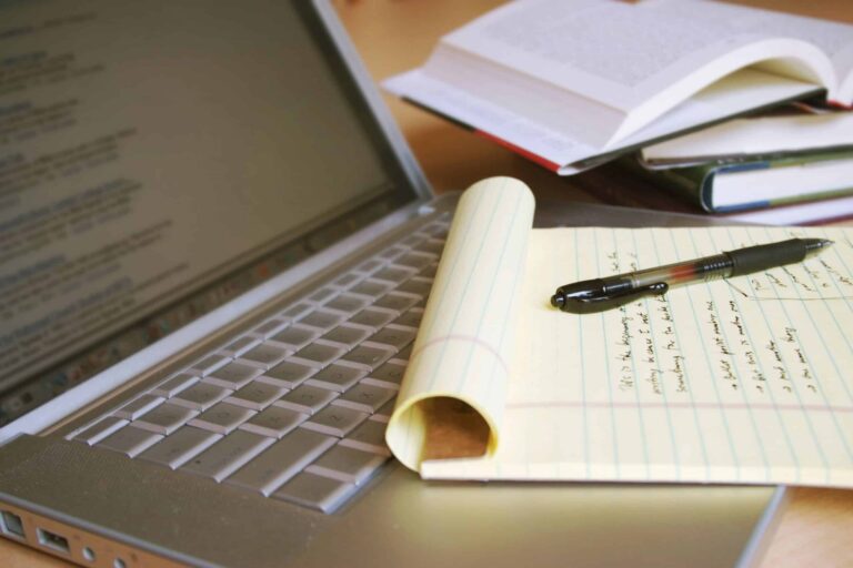 Pen, Laptop and a note book used for writing
